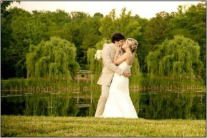 bride and groom kissing by lake