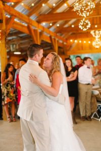 bride and groom first dance in rustic barn