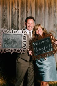 Parents of the groom holding photo op signs