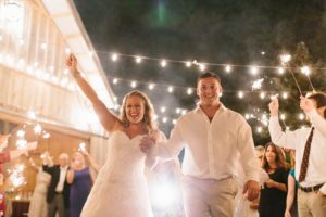 bride and groom walking outside under string lights