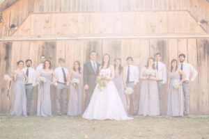 wedding party standing in front of vintage barn wedding venue