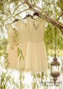 vintage brides maids dresses hanging on willow near lake