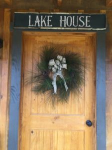 lake house sign above wooden door at vintage wedding venue