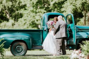 bride getting out of rustic truck at vintage wedding venue in georgia