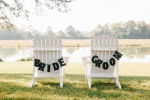 bride and groom chairs lakeside at vintage wedding venue in georgia